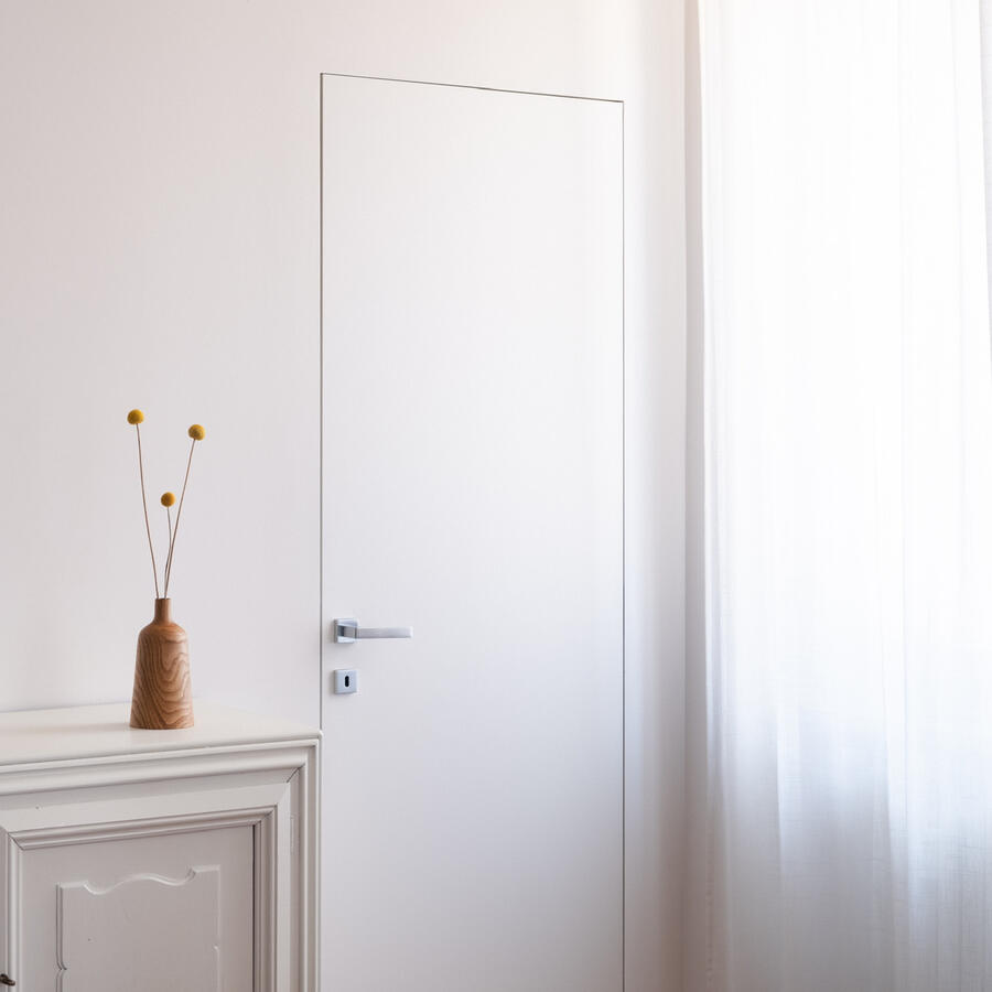 Soggiorno minimal con porta filomuro